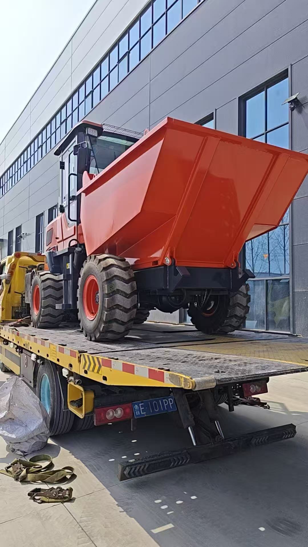 Orange site dumper on a flatbed road vehicle during YIHUI shipment preparation