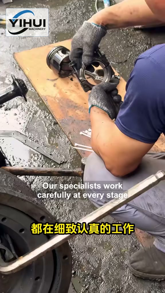 YIHUI technician holding an engine piston and connecting rod during workshop work